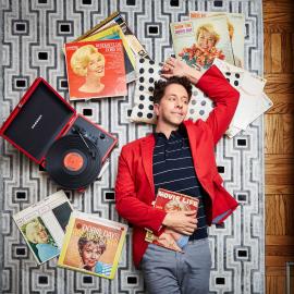 Man laying on the ground, surrounded by Doris Day albums.