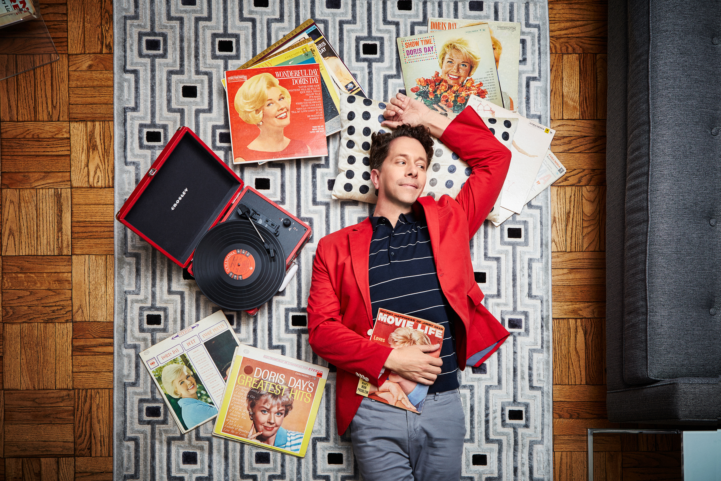 Man laying on the ground, surrounded by Doris Day albums.