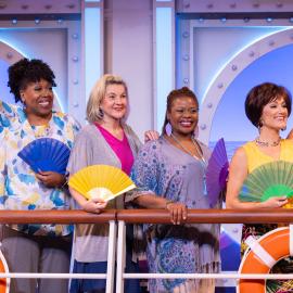 Four women standing on the deck of a cruise ship